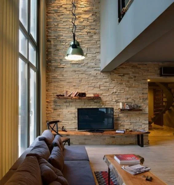 yüksek tavan modern salon uzun taş duvar doğal ahşap mobilya kalıcı estetik